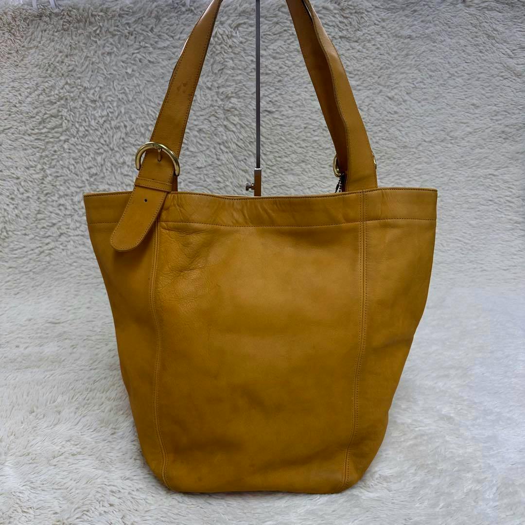Front view of the camel glove-leather Old Coach tote/shoulder bag on a light textured backdrop.