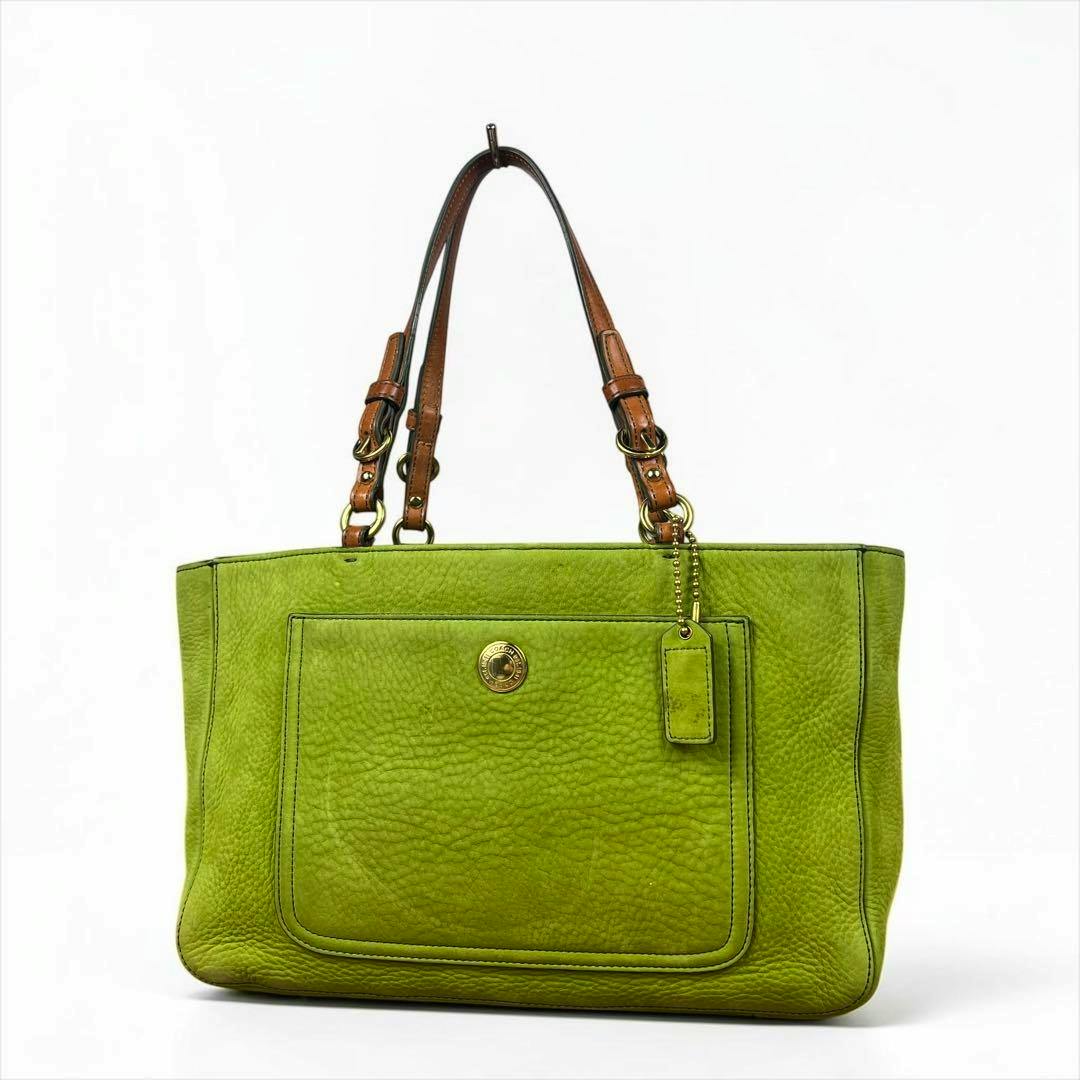 Green Coach suede bag with brown shoulder straps and a front pocket on a white background.