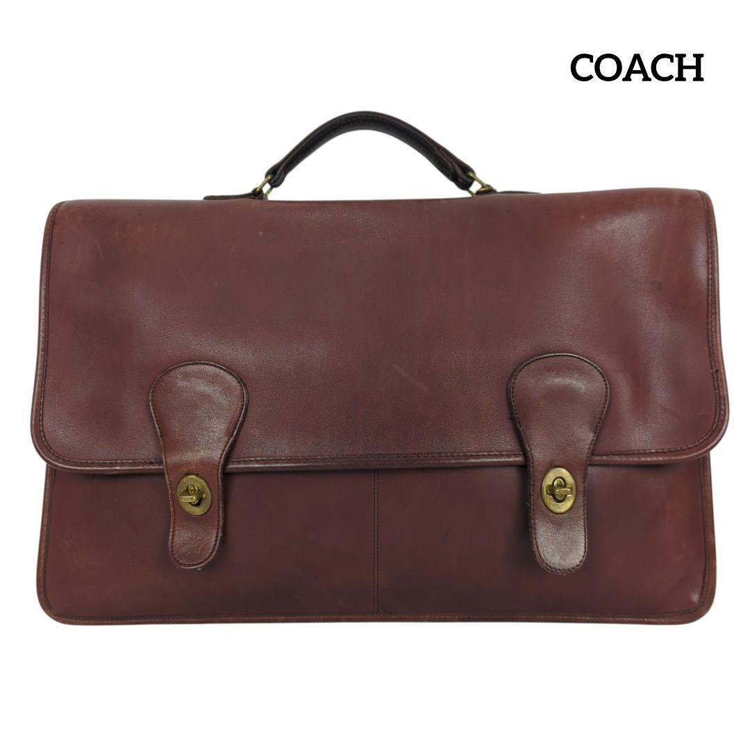Front view of an OLD COACH brown leather briefcase with two turn-lock closures and a top handle.