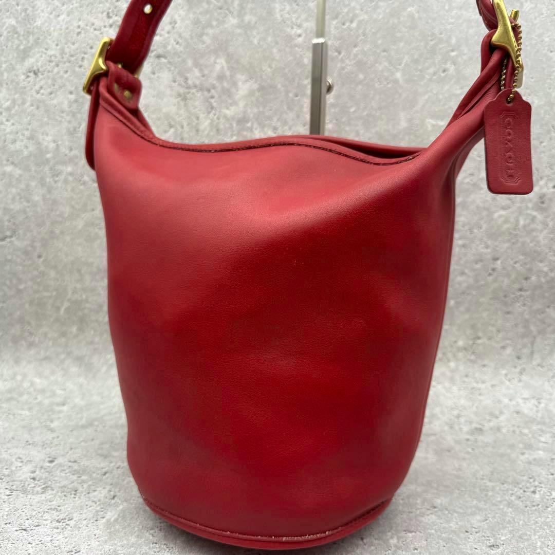 Front view of the red OLD COACH cow leather bucket shoulder bag against a gray background.