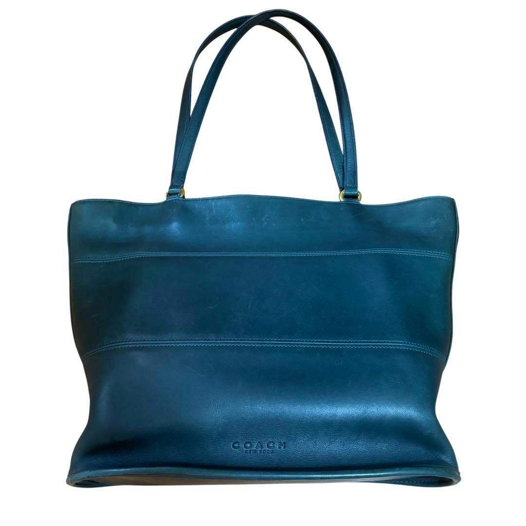 Front view of a green leather Coach tote bag with double shoulder straps and an embossed COACH logo on the front.