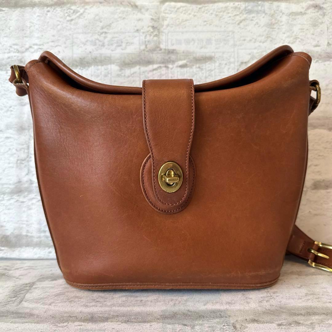 Front view of the Old Coach cow leather shoulder bag with a turnlock closure.