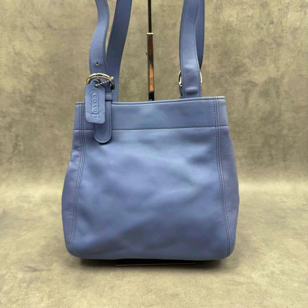 Front view of the blue Old Coach Waverly leather shoulder bag showing straps and a leather hang tag.