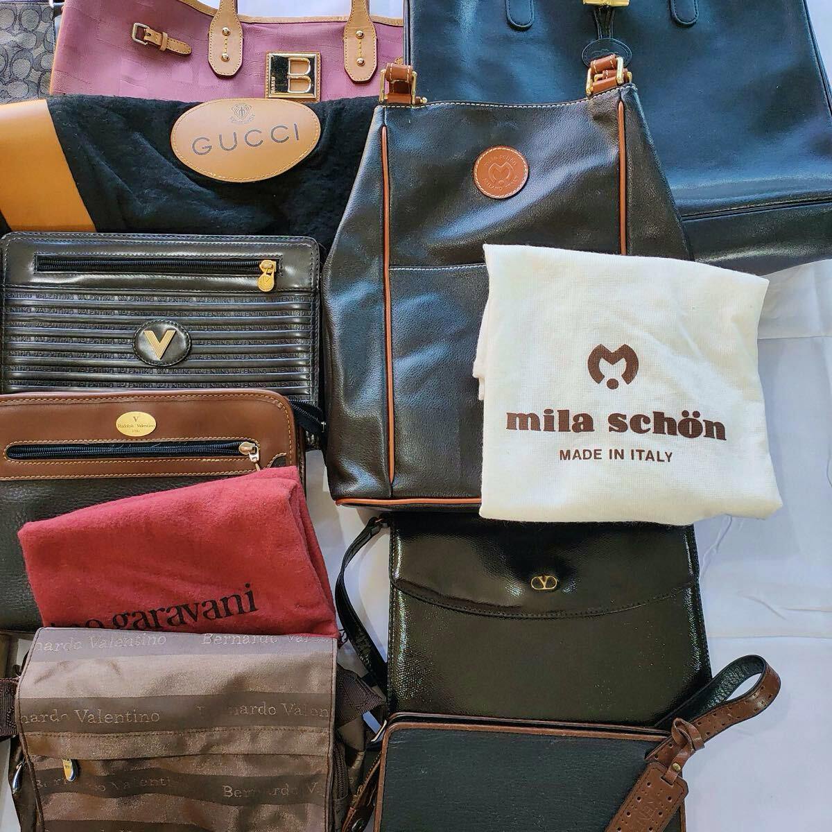 Multiple branded handbags and pouches laid flat, showing a visible GUCCI logo and a folded "mila schön" dust bag.