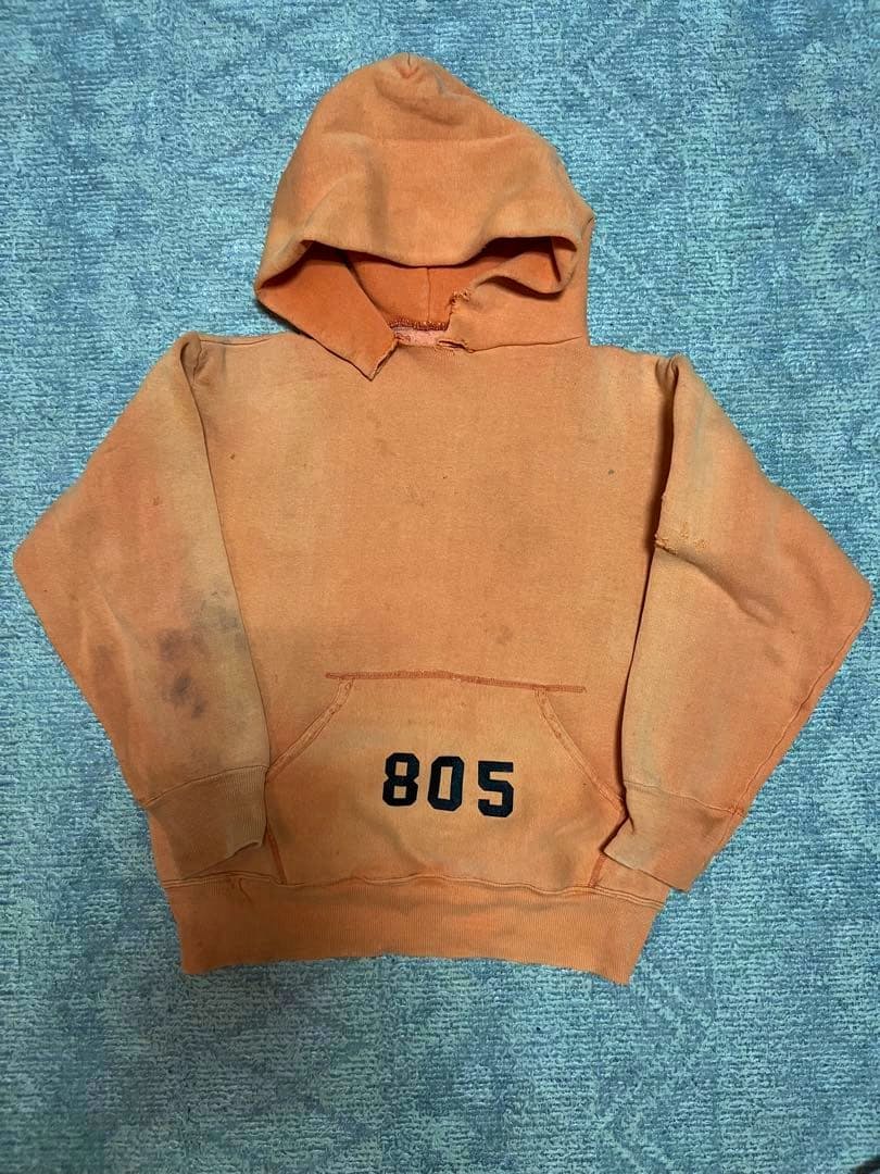 Faded orange vintage cotton hooded sweatshirt laid flat showing the front, kangaroo pocket, and '805' printed on the pocket.