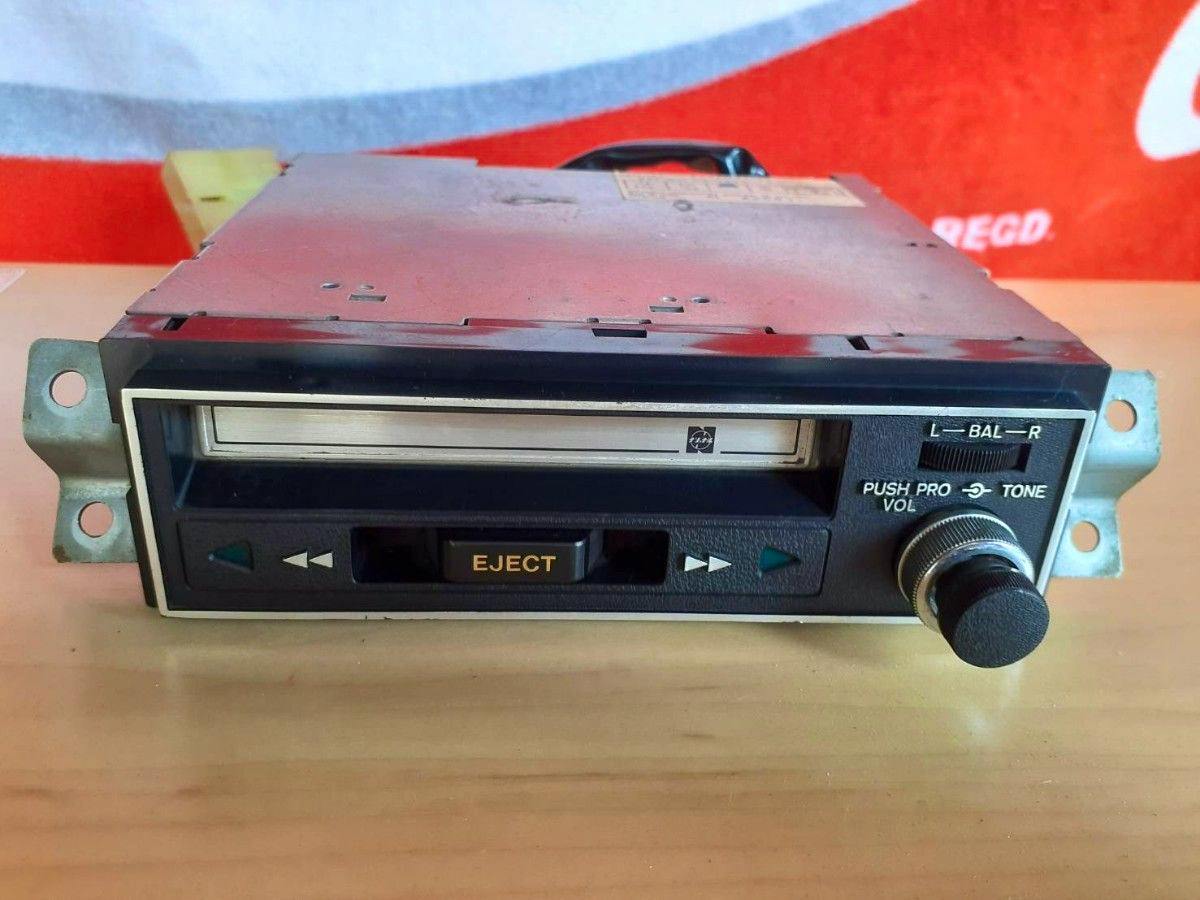 Front view of a cassette tape player showing the cassette slot, EJECT button, and control knob.