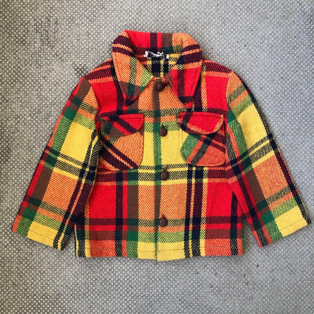 Front flat-lay of a children's vintage wool check shirt/jacket in red, yellow, orange and green plaid with brown buttons.