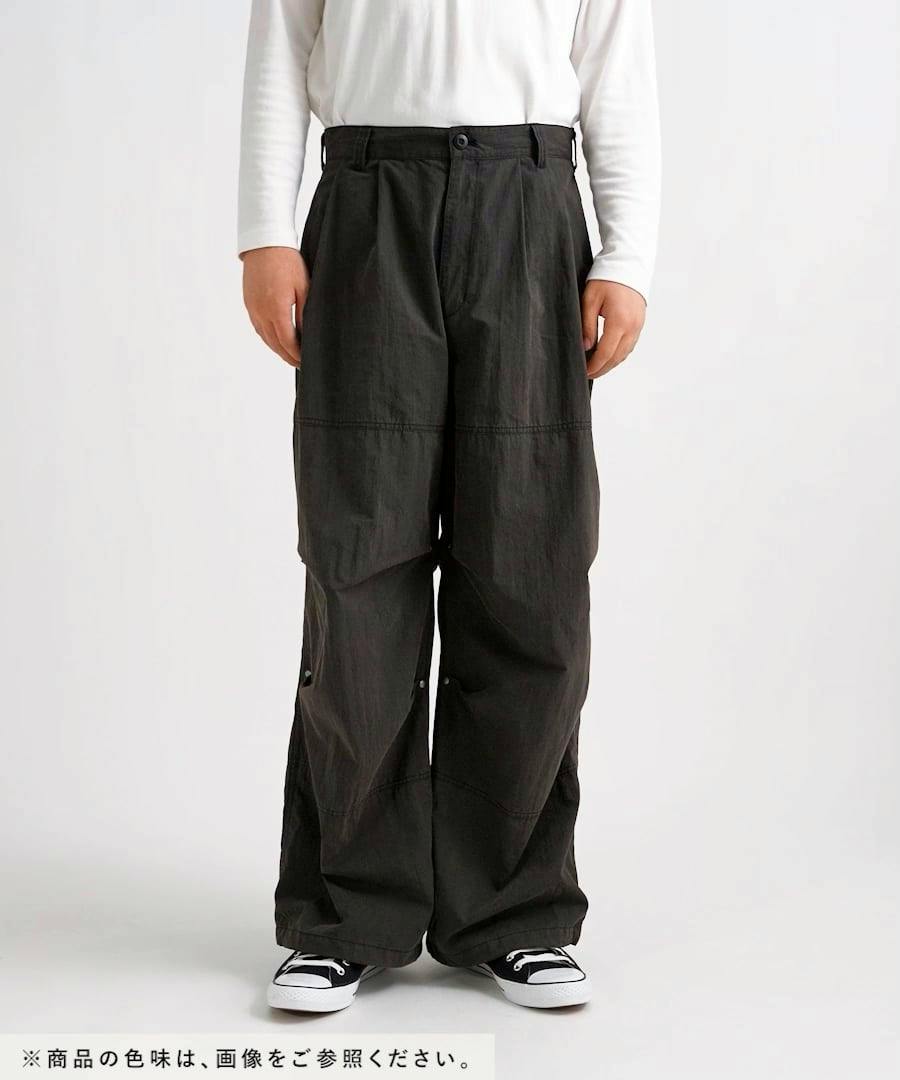 Front view of a model wearing vintage nylon men's baggy pants from waist to shoes.
