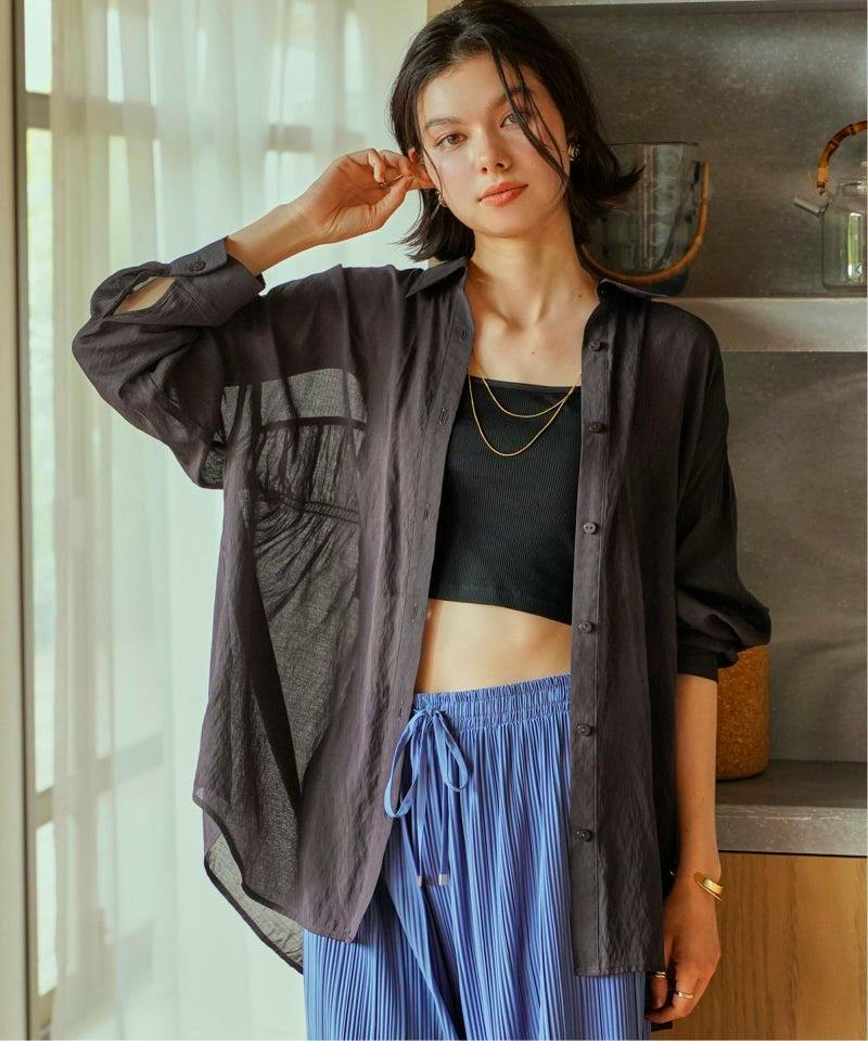Model wearing the dark sheer rayon button-up blouse with long sleeves and collar, shown open over a black crop top.
