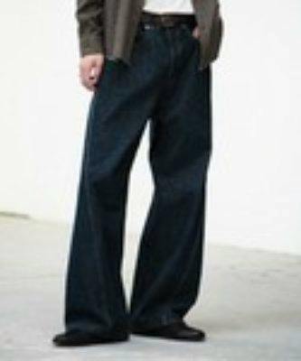 A person wearing dark washed men's curved denim jeans with a loose wide-leg fit.