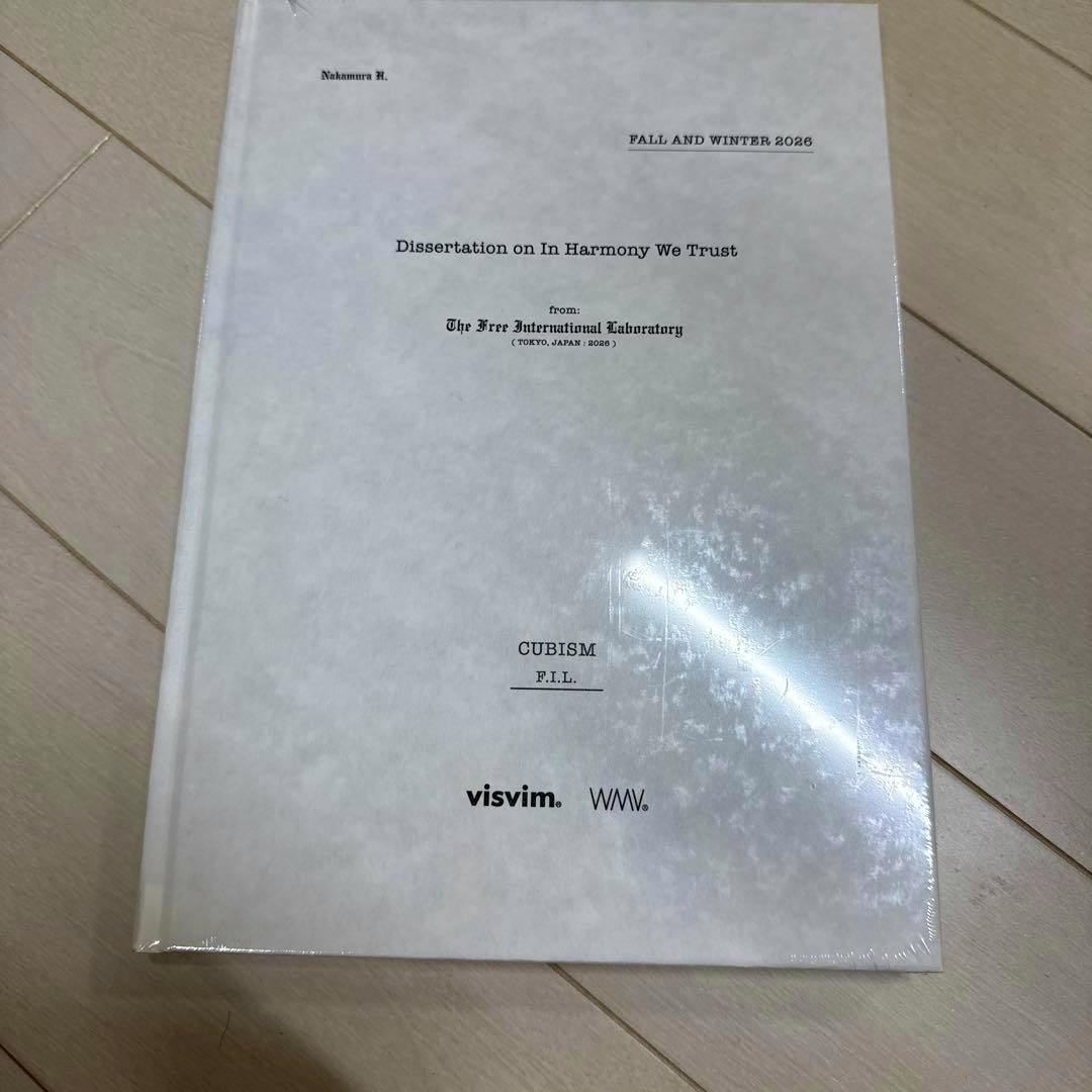Front cover of the visvim lookbook (Fall/Winter 2026) showing a white textured cover with the title "Dissertation on In Harmony We Trust" and the visvim logo.