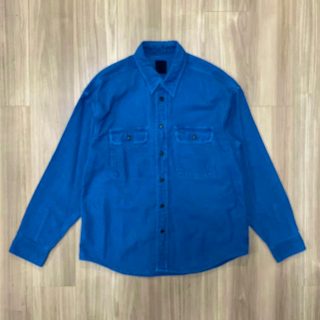 Blue long-sleeve men's cotton shirt laid flat showing the front with button closure and chest pockets.
