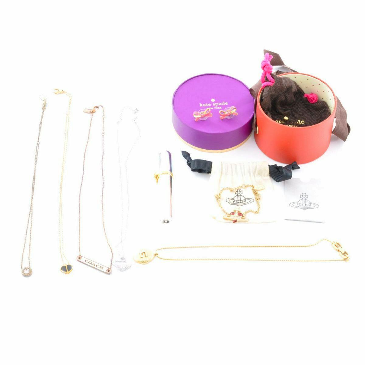 Several necklaces and brand pouches/boxes arranged flat, showing Vivienne Westwood, COACH, and kate spade items.