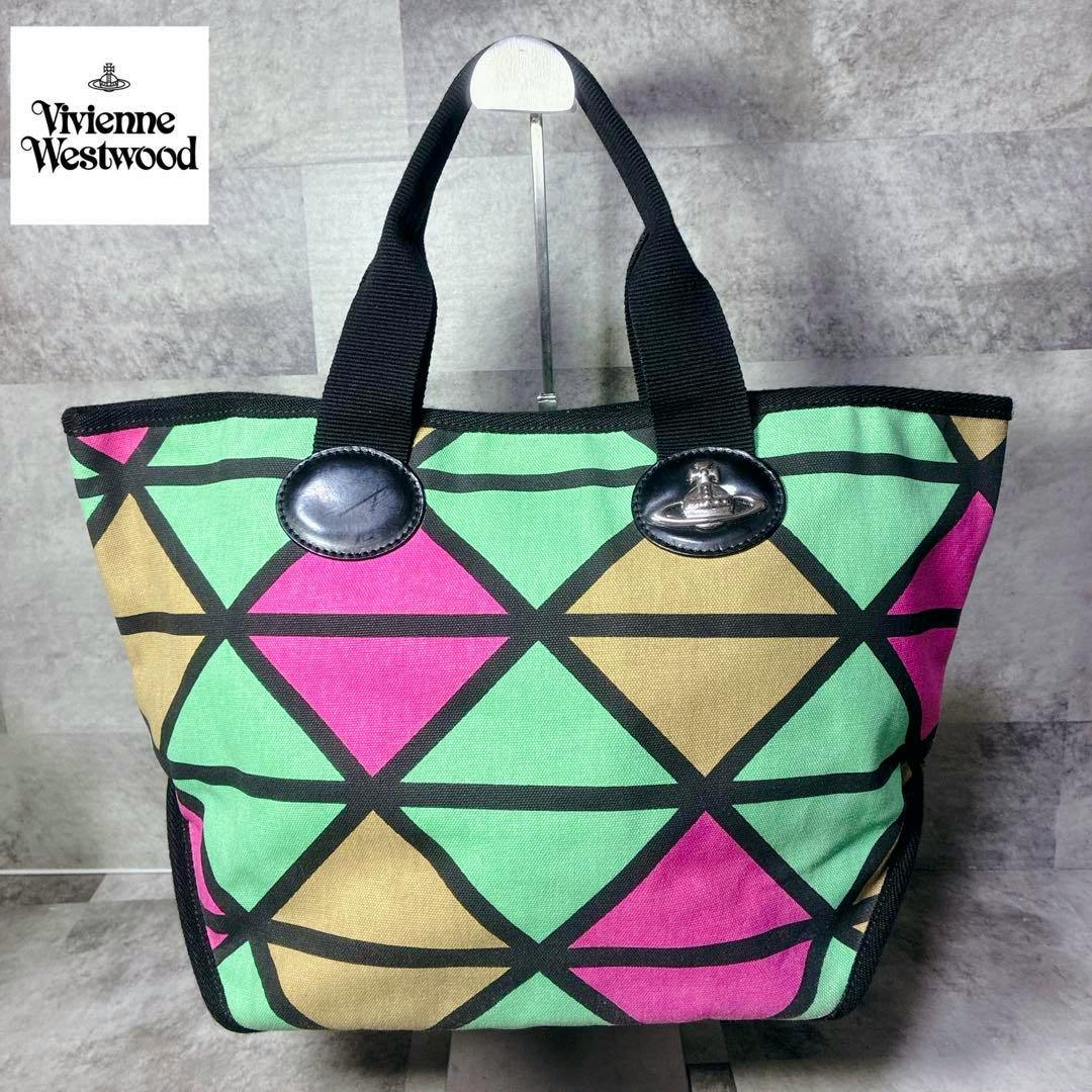 Front view of the Vivienne West Wood multicolor canvas tote bag with a geometric mint green, pink, and tan diamond pattern and black handles.