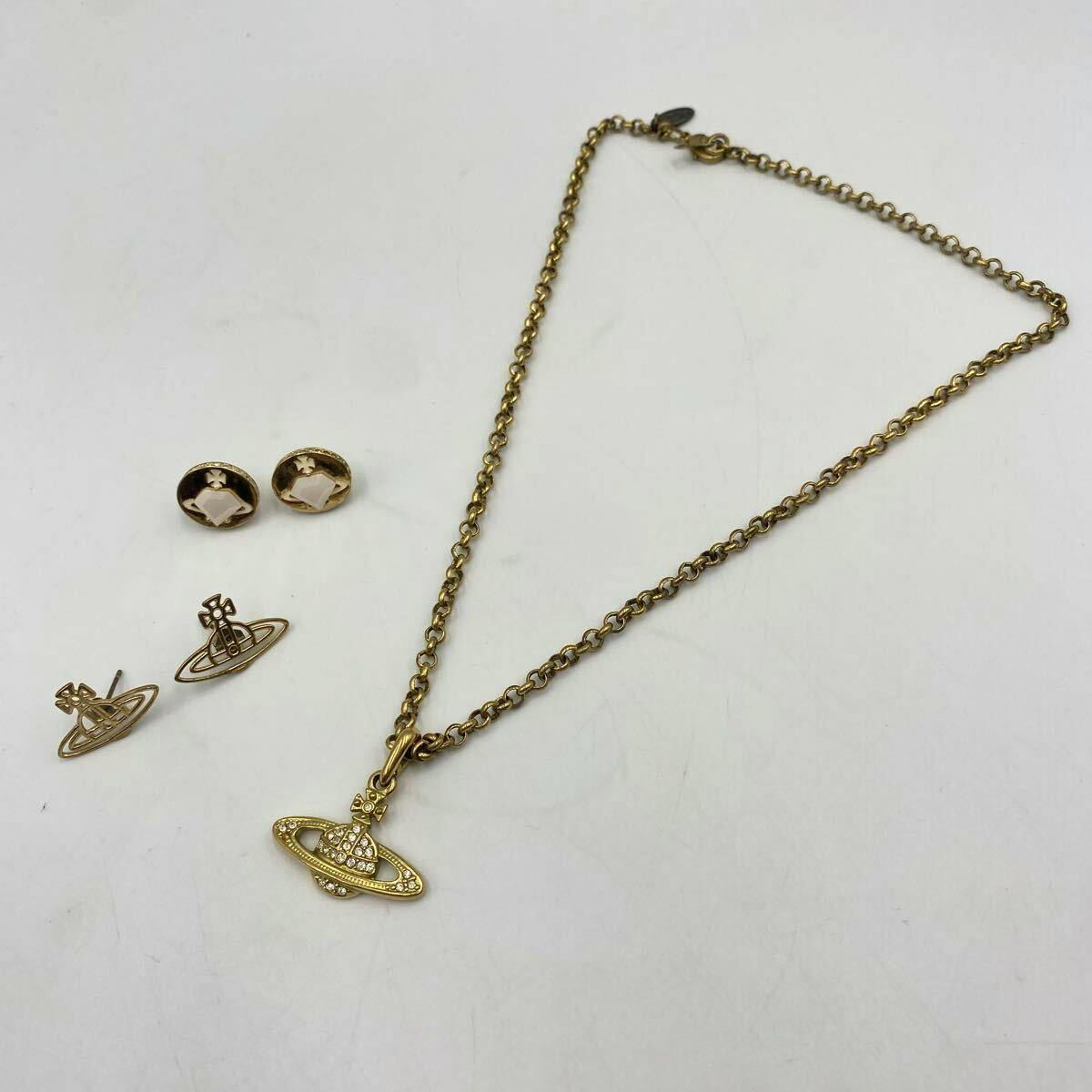 Gold-tone Vivienne Westwood necklace with orb pendant and two pairs of matching earrings on a white background.