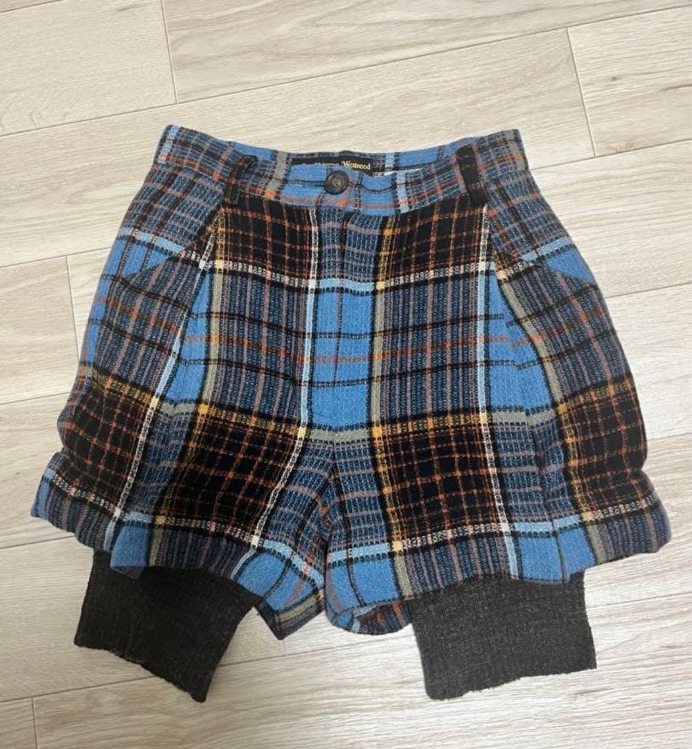 Front view of wool Vivienne Westwood women's shorts in blue plaid with grey knit leg panels laid flat on a wood floor.