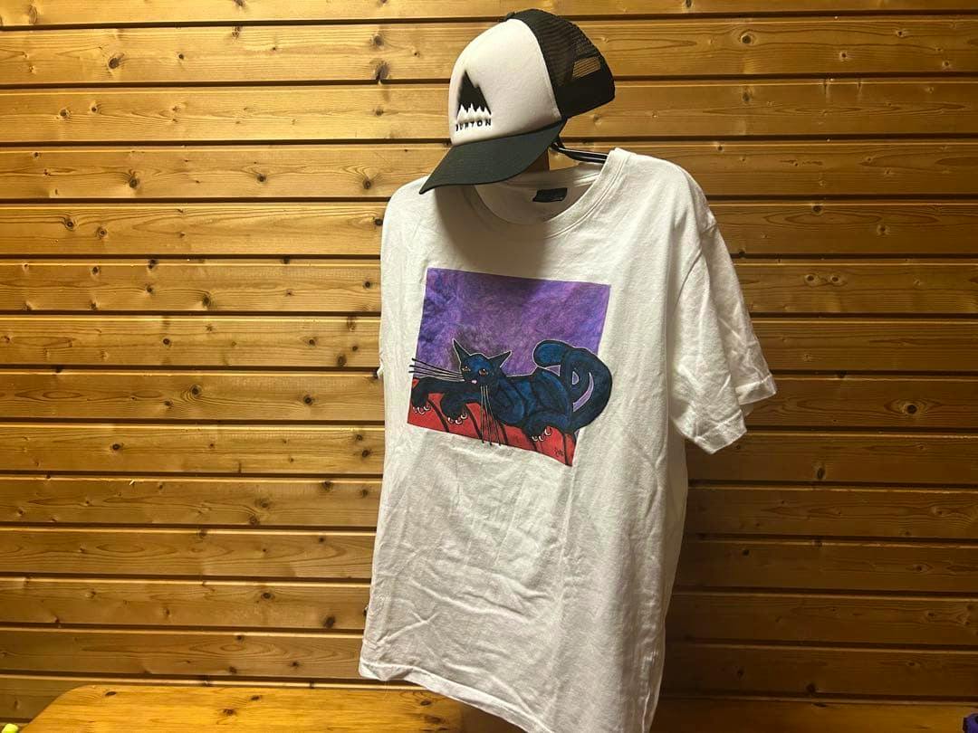 White VOLCOM Jamie Lynn men's L T-shirt hanging on a hanger showing the front black cat graphic.