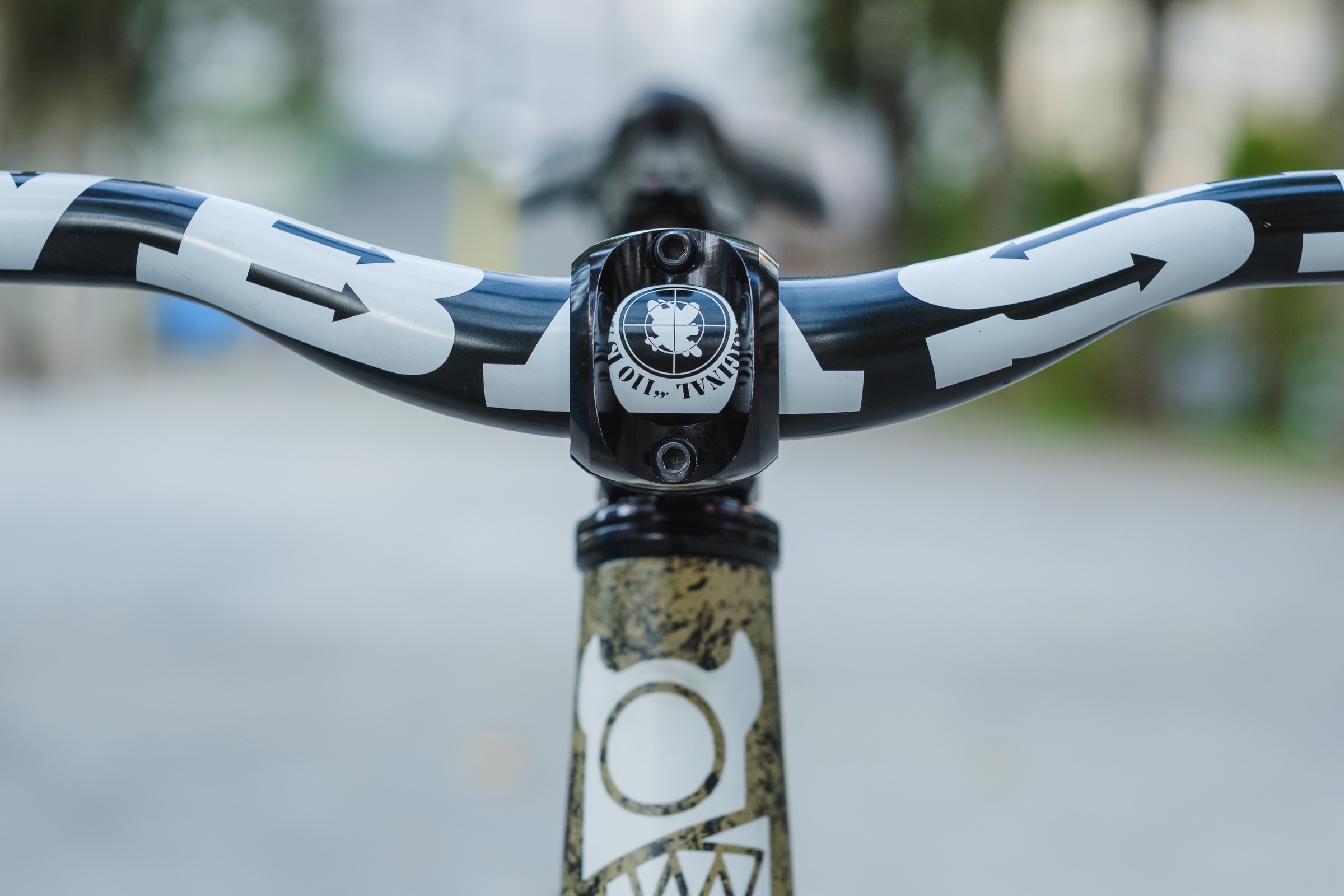 Front-on photo of the black bicycle handlebar with white graphics mounted on a bike stem.
