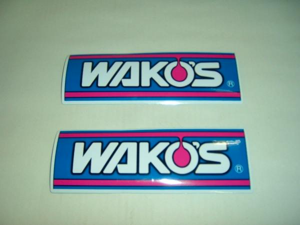 Two WAKO'S S-size rectangular stickers with a blue, pink, and white logo on a plain background.