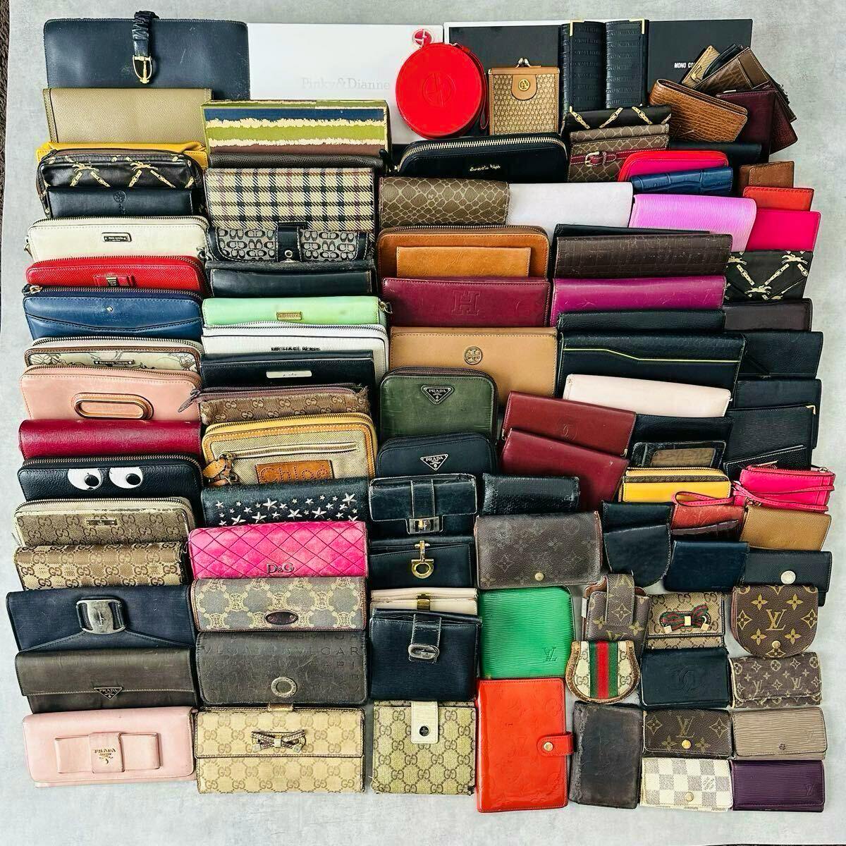 A large assortment of wallets and small leather goods arranged in a grid, showing various colors and brand patterns.