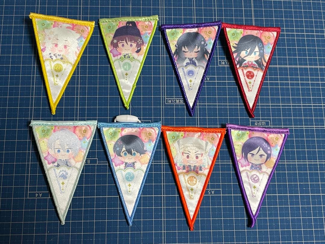 Eight triangular mini garland flags with character illustrations arranged on a cutting mat.