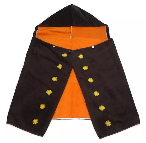 Hooded robe-style towel laid flat showing a black exterior, orange interior, and rows of yellow circular button motifs.