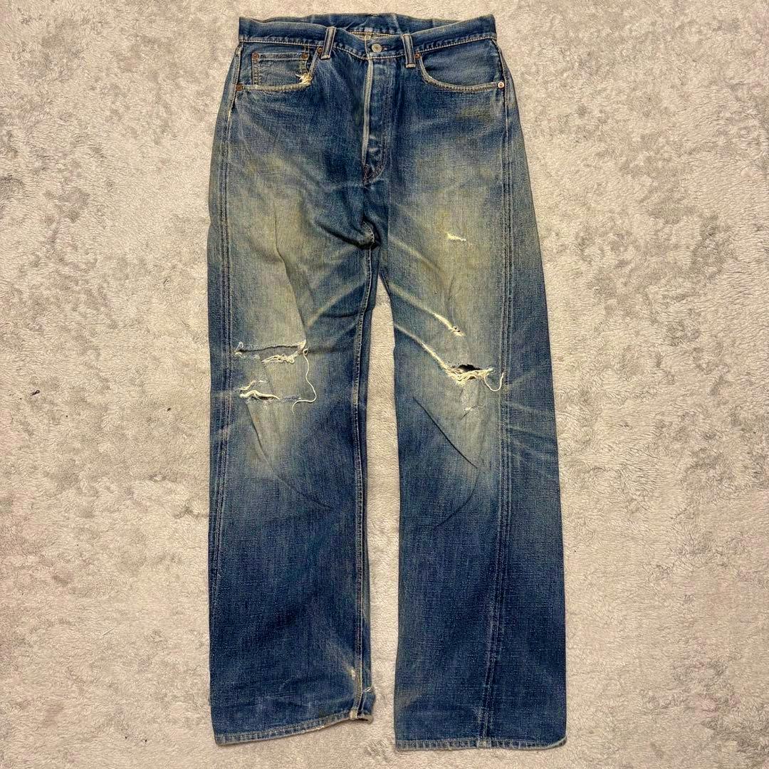 Front view of WAREHOUSE men's denim pants laid flat showing fade, distressing, and knee rips.
