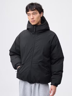 Male model wearing a black warm padded parka with hood, front zipper, and pockets.
