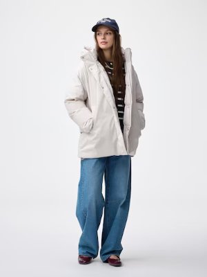 A model wearing the women's warm padded stitchless polyester coat in a light color, standing with hands in the pockets.