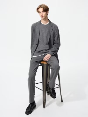 Male model seated on a stool wearing the listed men's Glen-check warm smart pants.