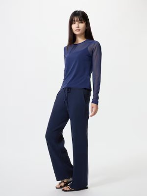Female model wearing navy knit rib pants and a navy long-sleeve top on a white background.