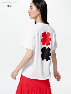 Back view of a model wearing a white crew-neck T-shirt with two large flower prints on the back.