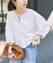 Model wearing the white lace bolero blouse shown from the front, holding a bag.