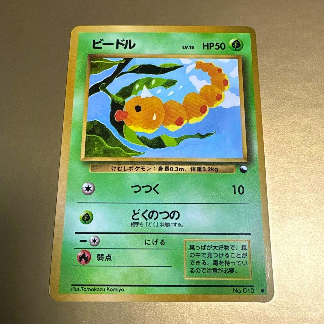 Photograph of a Japanese trading card (ビードル / Weedle) showing the full card face, artwork, and text.