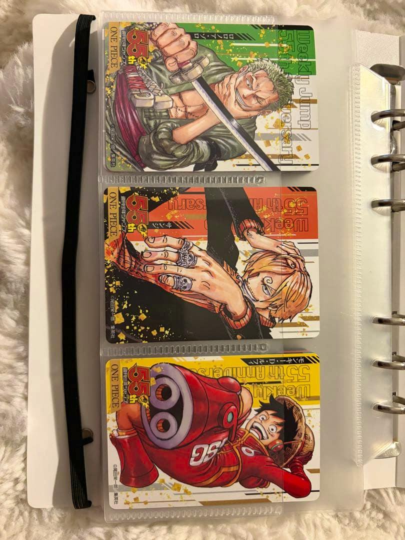 Three Weekly Jump 55th Anniversary collection trading cards (One Piece characters) displayed in clear plastic binder sleeves.
