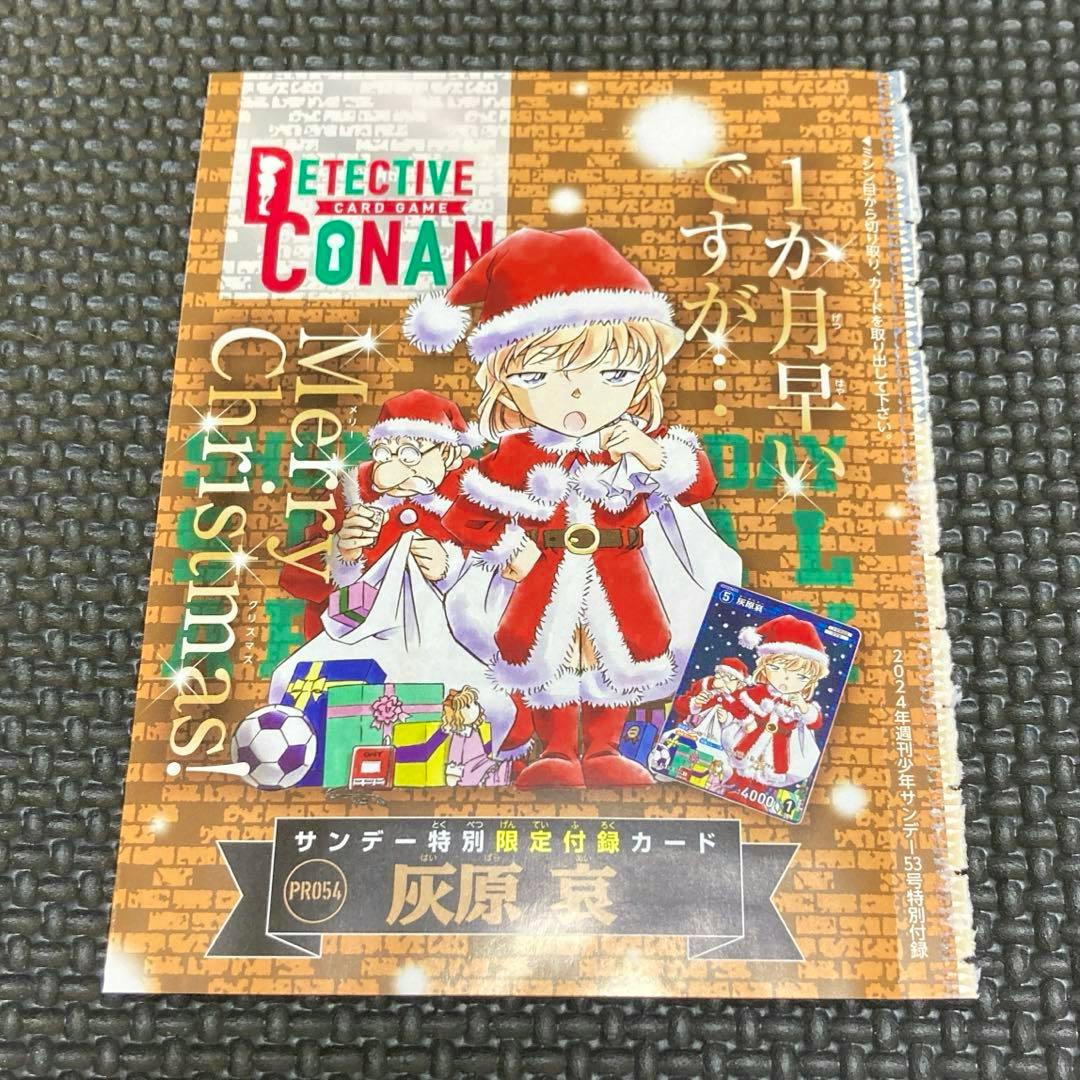 Photo of a Detective Conan promotional trading card and illustrated insert showing the character Haibara in a Santa outfit on a textured background.