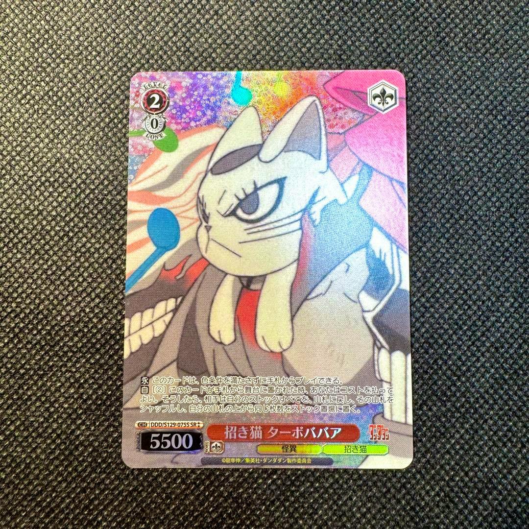 Photograph of the trading card '招き猫ターボババア SR パラレル' showing the illustrated cat character and card text on a textured background.