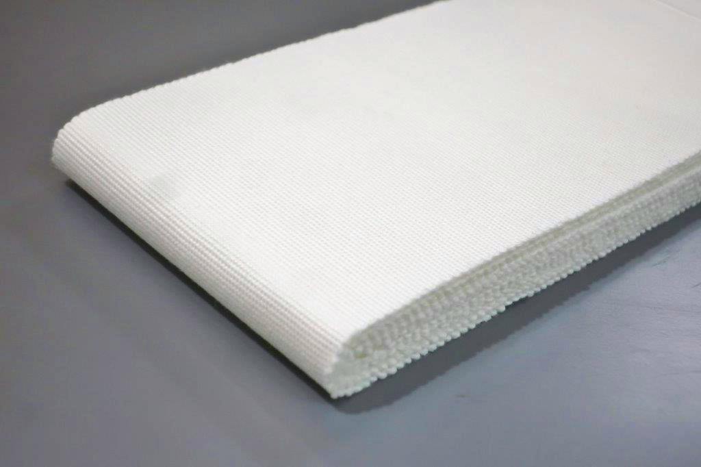 Folded white cotton fabric belt showing weave texture and edge on a gray surface.