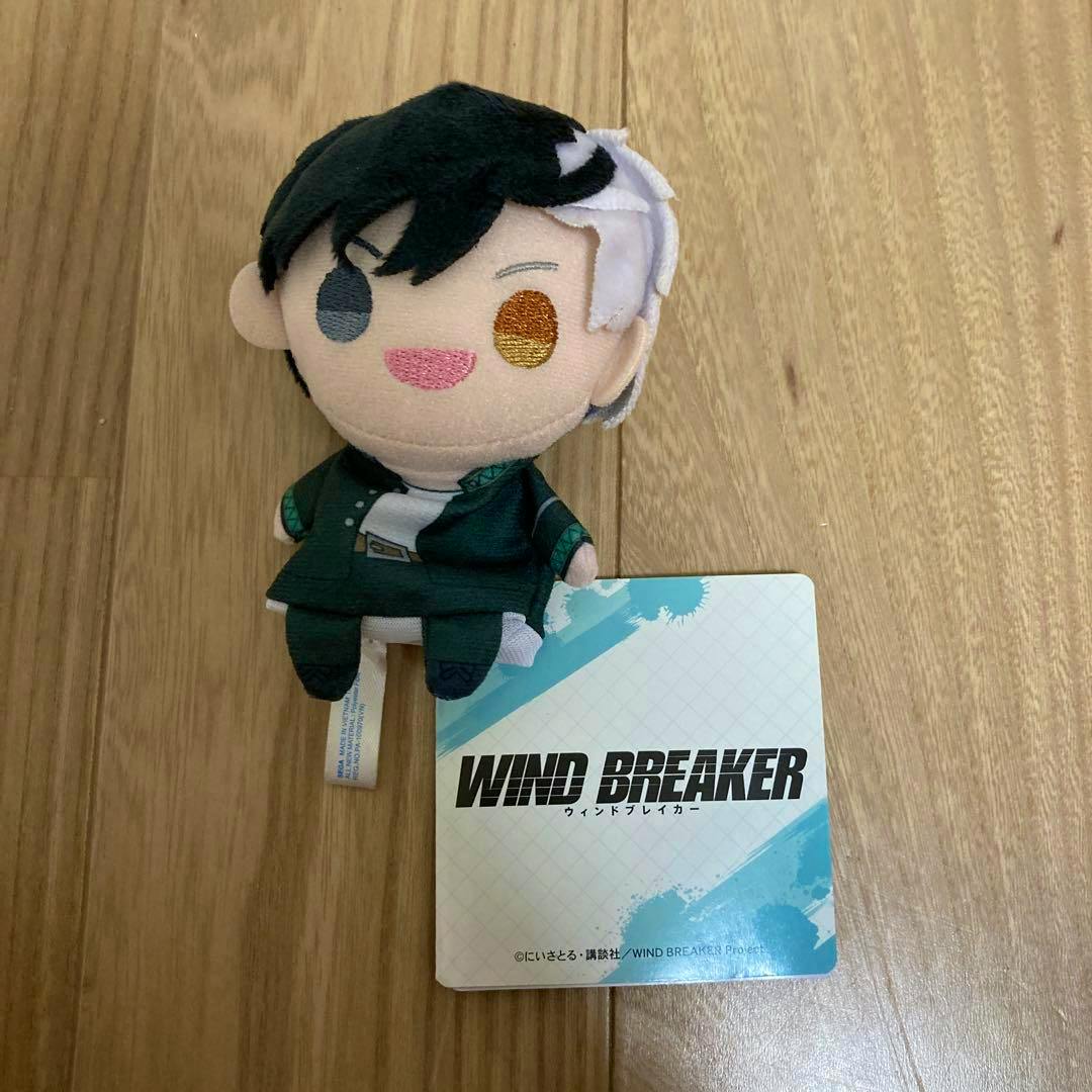 Front view of the WIND BREAKER finger-puppet plush (桜遥) on a wooden floor with its product tag visible.