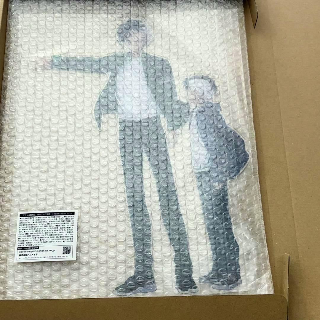 Bubble-wrapped acrylic stand (Wind Breaker Vol.26) showing two character silhouettes inside a cardboard box.