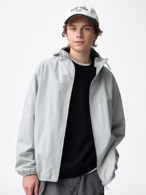 Male model wearing a light gray windproof shell parka against a white background.