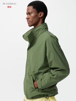 A male model shown in profile wearing a green men's windproof stand-collar nylon jacket.