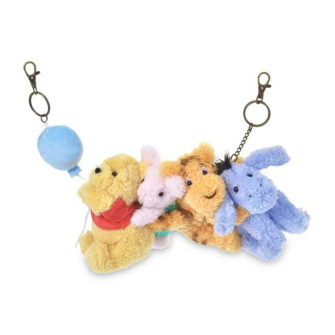 Plush bag charm showing Winnie the Pooh, Piglet, Tigger, and Eeyore linked together with metal clasp keychain attachments.