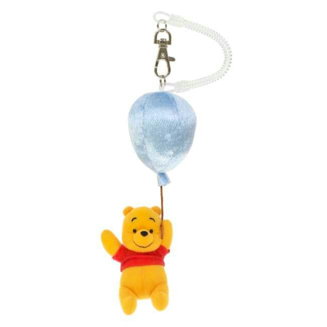 A plush Pooh keychain charm hanging from a blue balloon with a metal clasp.