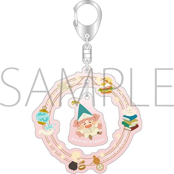 Acrylic keychain showing a pink circular double-part charm with a small character wearing a pointy hat and surrounding decorative icons, attached to a metal keyring.