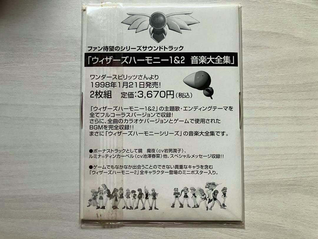 Sealed CD sleeve photographed from the back showing Japanese text about the Wizards Harmony soundtrack, release information, and small character illustrations at the bottom.
