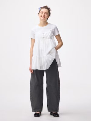 Model wearing dark barrel-leg jeans with a white top against a plain white background.