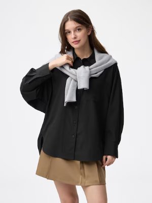 Woman modeling a black women's dolman sleeve button-front shirt with a gray sweater draped over her shoulders.