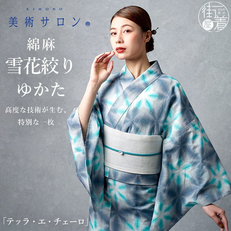 Woman modeling a blue-green patterned cotton-linen yukata for women with a light-colored obi against a gray background.