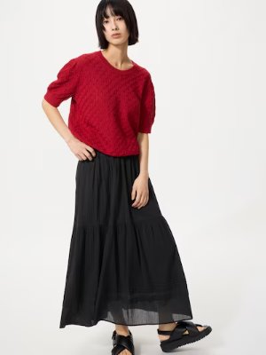 Model wearing the women's black skirt with a red top against a white background.